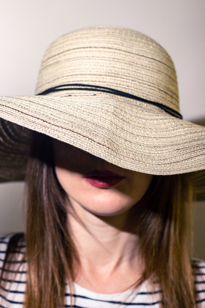 Sun Protection After Laser Hair Removal Woman wearing a wide-brimmed sun hat that shades her face.